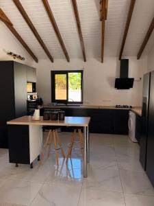 a kitchen with a counter and a table in a room at Villa Sheba in Lamentin