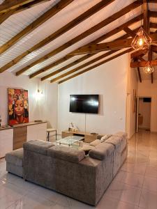 a living room with a large couch and a flat screen tv at Villa Sheba in Lamentin