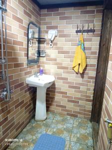 a bathroom with a sink in a brick wall at Aframe in Forest & Lake in Quba