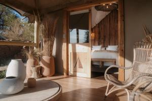 a room with a bedroom with a bed and a chair at UNAI Atacama Luxury Tents in San Pedro de Atacama