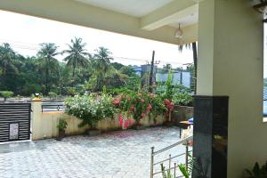 a patio with flowers on a wall and a fence at Anugraha Bed&Breakfast Homestay in Kumta