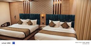 two beds in a hotel room with at Hotel Mantavya in Kakarmatha +149 photos