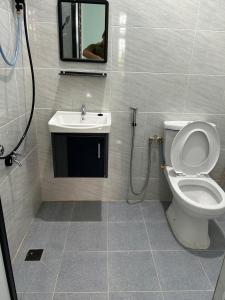 a bathroom with a toilet and a sink at Homestay Adilah D in Selising