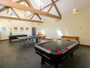 a room with two ping pong tables and pool tables at The Old Cart Shed in Blandford Forum