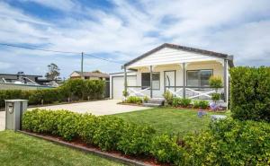a small white house with a yard at Salt Water Breeze -pet friendly-spa! in Culburra Beach