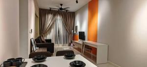 a living room with a table with chairs and a television at Sunway Geo Suites CA0F at Sunway City by Ezprop in Subang Jaya