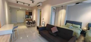 a living room with a bed and a couch and a kitchen at Sunway Geo Suites CA0F at Sunway City by Ezprop in Subang Jaya