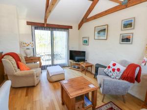 a living room with chairs and a table and a tv at Casa Mia in Goodwick