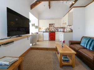 a living room with a couch and a tv and a kitchen at Bay View Apartment in Porthmadog