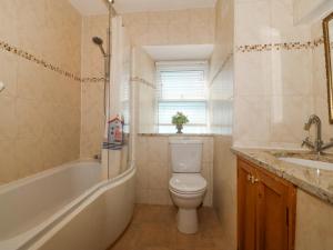a bathroom with a toilet and a tub and a sink at Bay View Apartment in Porthmadog +30 photos