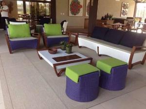 a living room with couches and stools and a table at Malawi Resort Essence in Porto De Galinhas