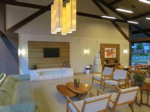 a living room with a couch and tables and a tv at Malawi Resort Essence in Porto De Galinhas