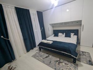 a bedroom with a bed with blue sheets and curtains at Edmay Byrelax in Sighetu Marmaţiei