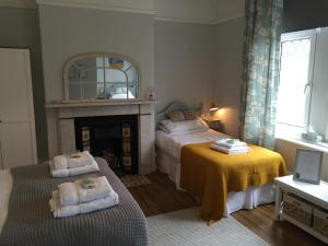 um quarto com 2 camas e uma lareira em Sandsides Guest House em Whitley Bay