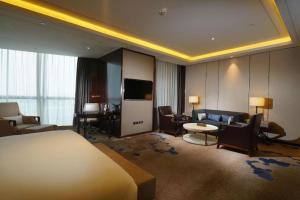 a hotel room with a bed and a living room at Beijing Grand Skylight International Hotel in Beijing