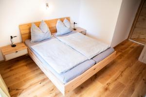 a bedroom with a bed with white sheets and blue pillows at Appartement am Moserhof in Stein an der Enns