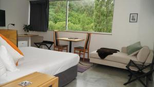 a room with a bed and a couch and a table at The Arrow Hotel in Arrowtown