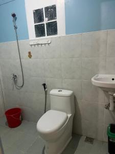 a bathroom with a toilet and a sink at Lugadia Inn- Abels El nido in El Nido