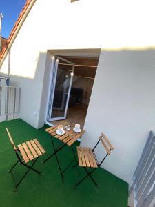 two chairs and a table on a balcony with green grass at barrierefreier Neubau im Zentrum in Marktbreit