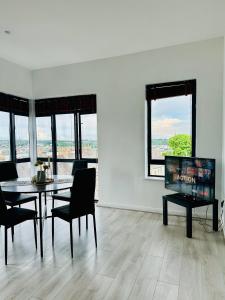 a dining room with a table and chairs and windows at Skyline Vista Apartment in Waterford +6 photos