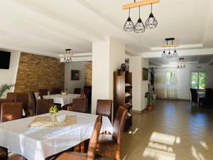 a dining room with tables and chairs and a brick wall at PASTRAVARIA ALINA in Sîrbi
