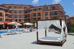 a canopy bed in front of a hotel with a pool at Family Apartment Near Beach, Pools & Star dreams Complex in Sveti Vlas
