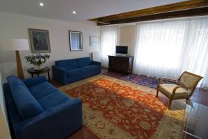un salon avec deux canapés bleus et une télévision dans l'établissement Sarai Apartments, à Venise