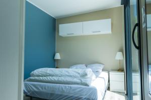 a bedroom with a bed with blue walls and a mirror at La Tiny L Loches, proche Zoo de Beauval in Loches