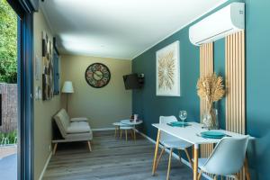 a dining room with blue walls and a table and chairs at La Tiny L Loches, proche Zoo de Beauval in Loches