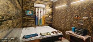 a bedroom with a bed in a stone wall at Hotel O Mo Kudia in Brahmapur