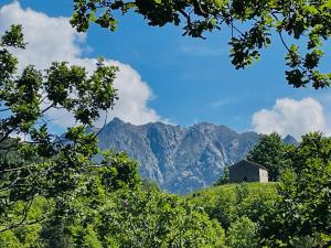 un granero en una colina con montañas en el fondo en appartement de montagne corsica, en Sampolo 3 fotos más