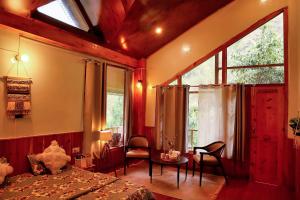 BanjārにあるBoho Grove Cafe & Stay, Tirthan Valleyのベッドとテーブルと椅子のある寝室