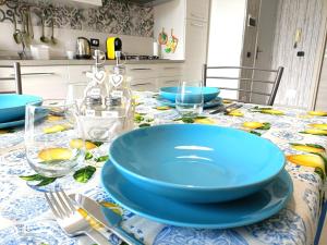 a dining table with blue bowls and plates on it at Scirocco Blu - Casa al Mare in Donnalucata +9 photos