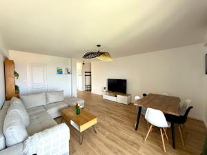 a living room with a couch and a table at Appartement spacieux, moderne, vue mer proche plage et centre-ville in Bastia