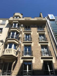 un edificio alto con balcones a un lado. en Hotel Auguste, en París