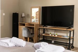 a bedroom with a tv and a bed with towels at Vot Villas in Ormos Panagias