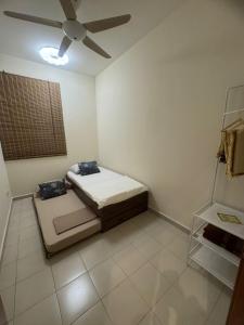 a bedroom with two beds and a ceiling fan at DQuatro Homestay in Kampong Jelatang