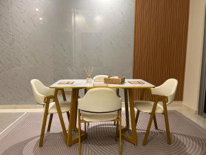 a wooden table with white chairs and a tableablish at DQuatro Homestay in Kampong Jelatang +5 photos