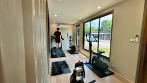 a man is exercising in a gym with windows at Mangrove Prestige Hotel in Na Jomtien