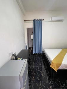 una camera d'albergo con letto e tenda blu di Romnea Moon Resort a Krong Saen Monourom