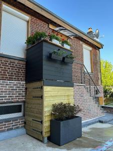 a wooden dresser with plants on top of a house at Le Refuge de la Gravière in Charleville-Mézières