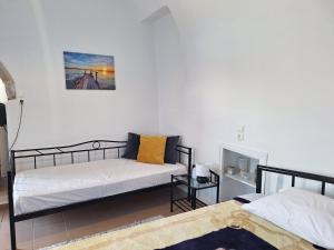 a bedroom with two beds and a fireplace at Volto Studio in Kythira