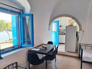 a kitchen and dining room with a table and a refrigerator at Volto Studio in Kythira