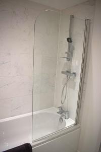 a shower in a bathroom with a bath tub at Tolson Court House in Fazeley