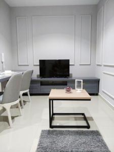 a living room with a tv and a table and chairs at Happy Holiday,I-Soho, I-City, Shah Alam ,Free Wifi & Parking in Shah Alam