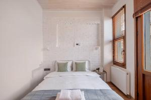 a white bedroom with a bed and a brick wall at Istanbul House Oldtown in Istanbul