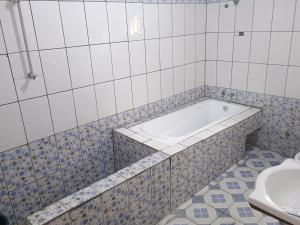 een badkamer met een bad en een toilet bij Sky Blue VIP Guest House Buea in Buea