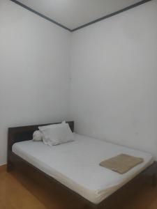 WahaLabore Homestay的一张白色的床，上面放着两个枕头