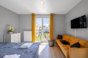 a living room with a couch and a television at Apartament przy Błoniach in Rumia
