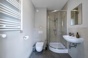 a bathroom with a sink and a shower and a toilet at Apartament przy Błoniach in Rumia +6 photos